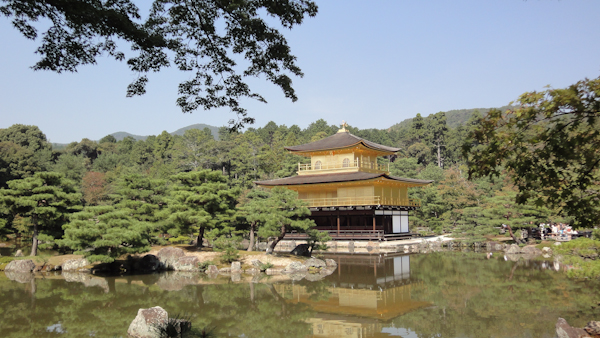 the temple from a distance is also relected in the water of a pond